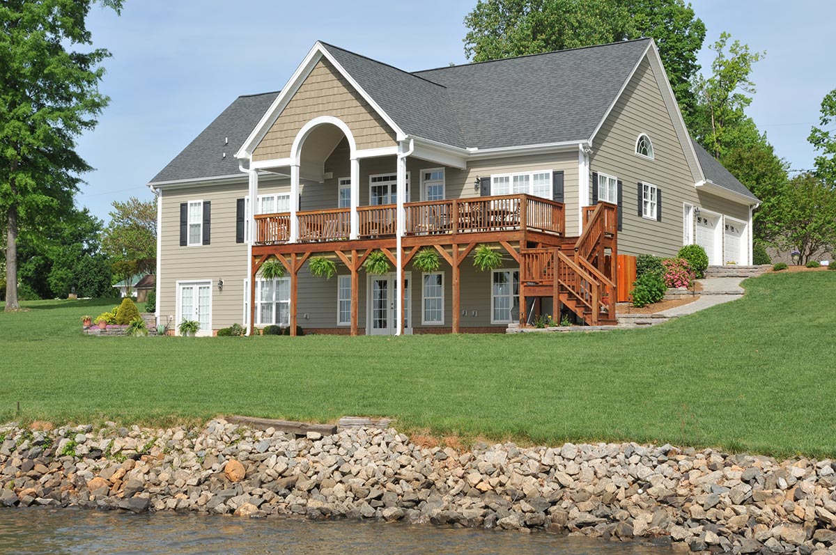 Large home with gray siding on the water