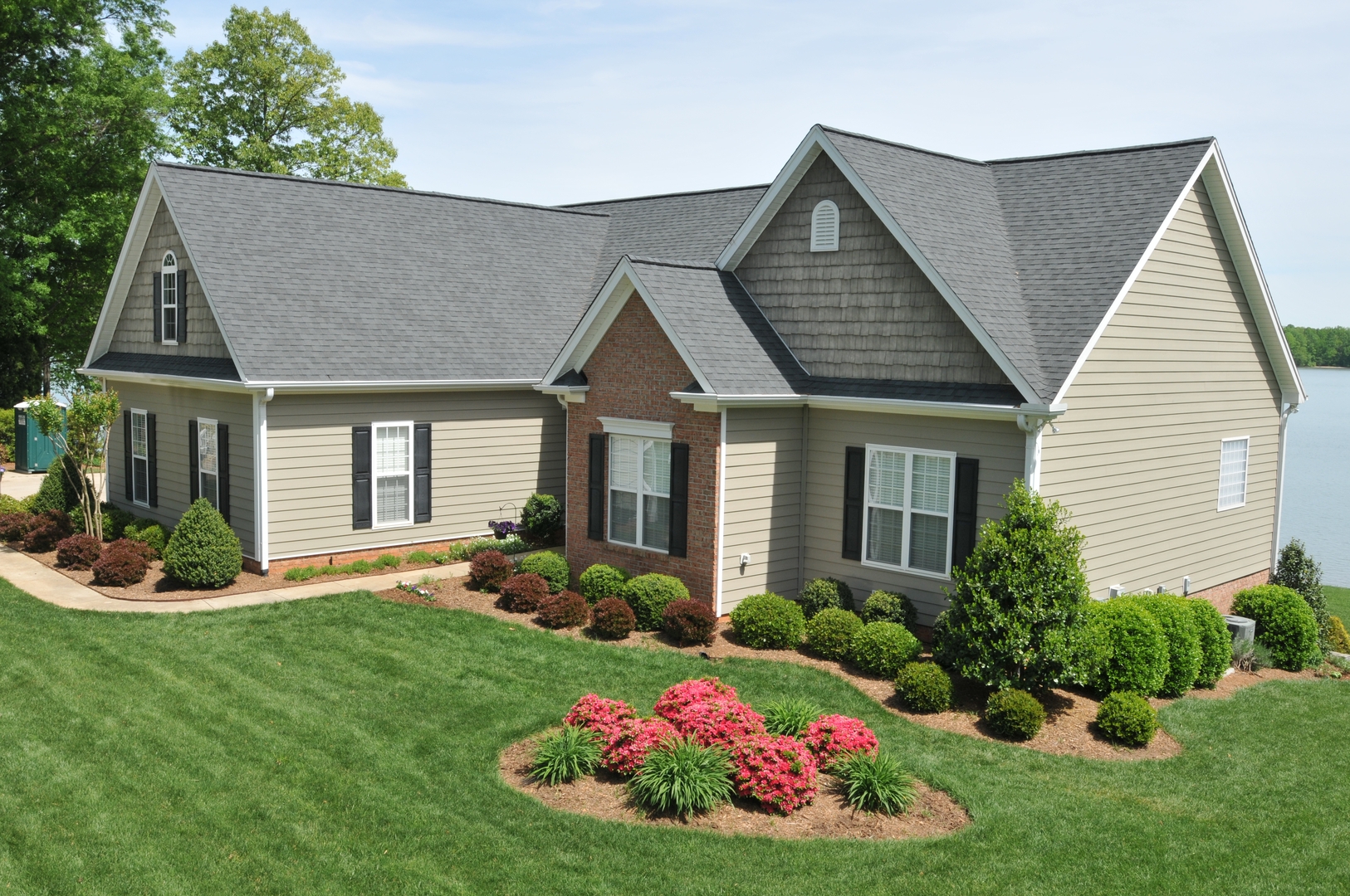 Tan vinyl siding on lakefront craftsman home